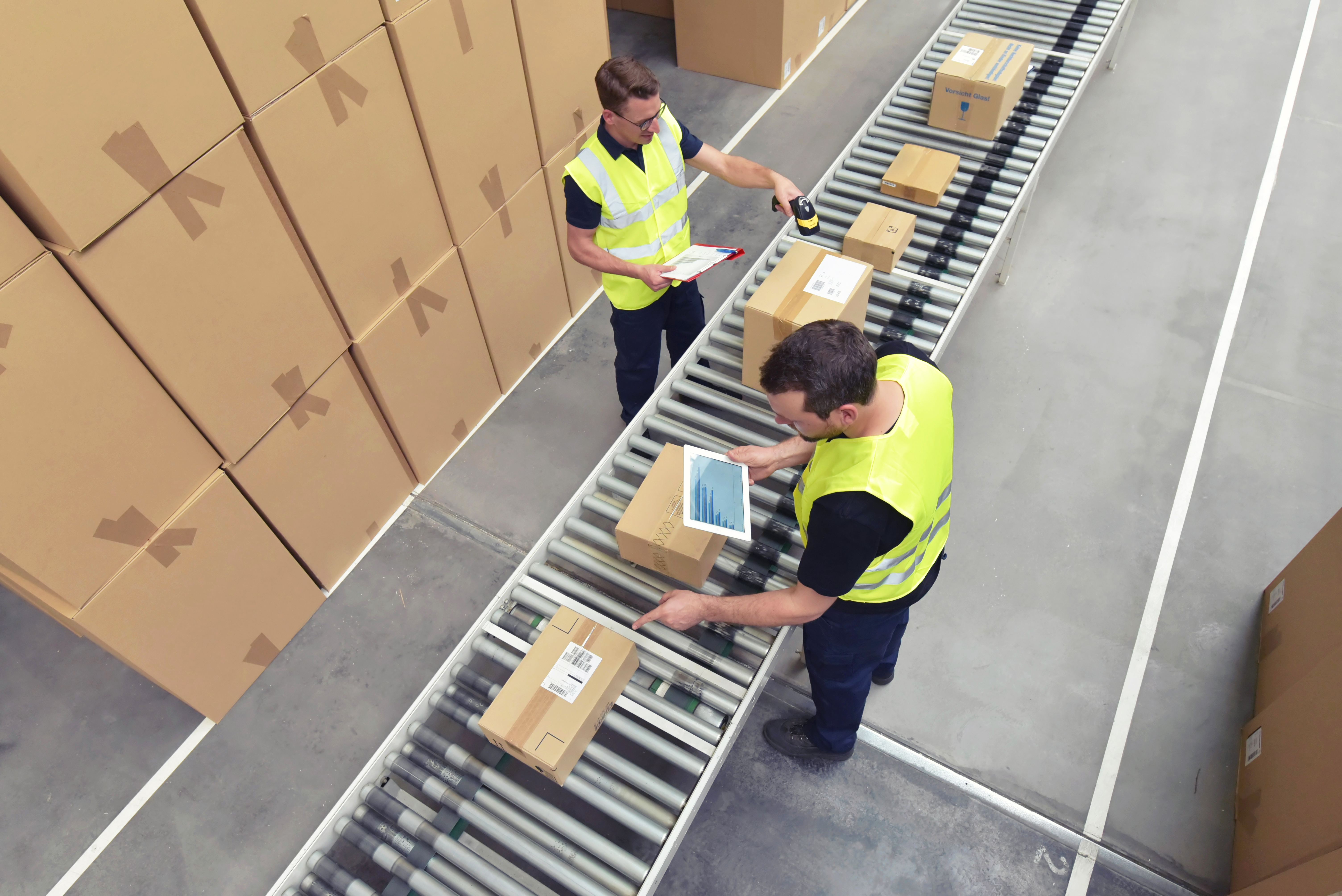 Overhead View of Two Men in Safety Vests in a Shipping Warehouse