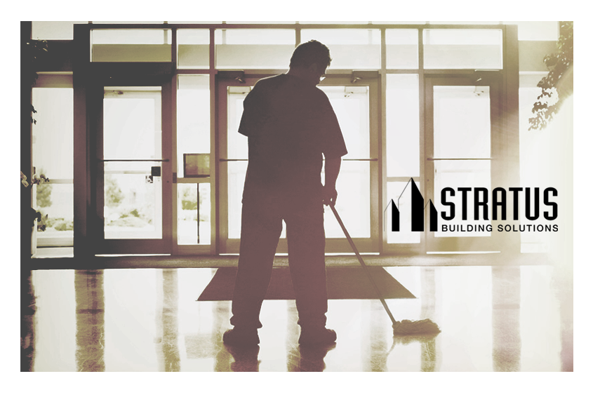 A janitor mopping the entryway of a building with the Stratus logo in black on the right side.