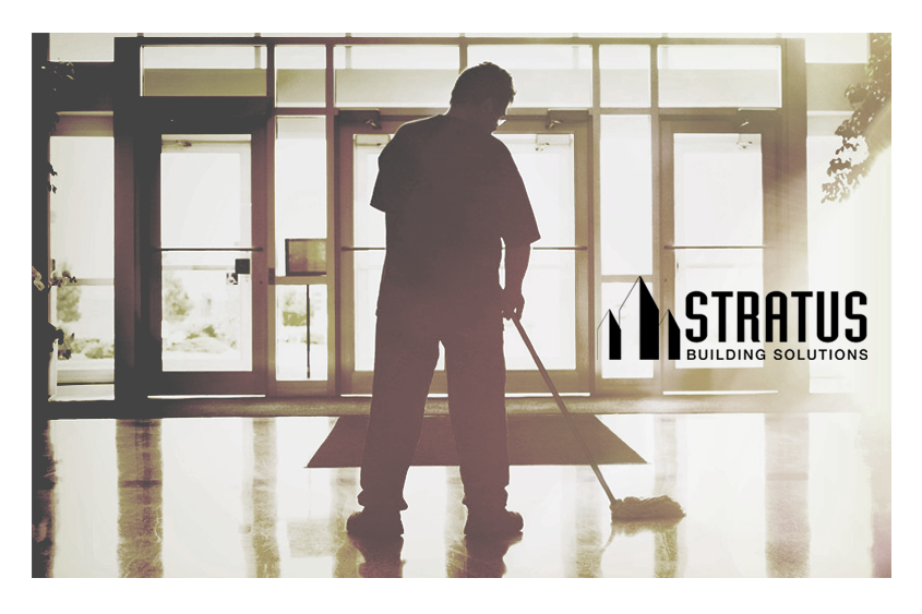 A janitor mopping the entryway of a building with the Stratus logo in black on the right side.