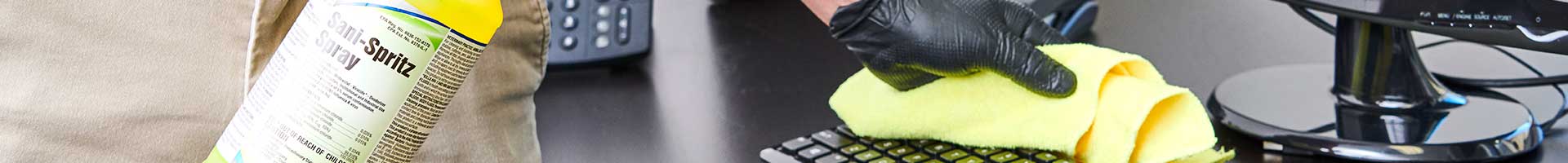 A Stratus Franchisee if Cleaning an Office Computer Using a Stratus Branded Disinfecting Spray