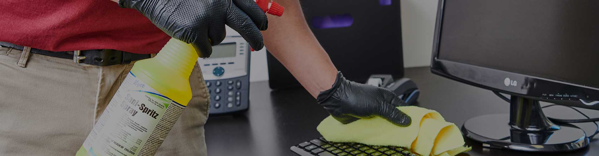 A Close Up Image of a Stratus Unit Franchisee Cleaning a Computer Keyboard in an Office Building Using the Stratus General Purpose Cleaner