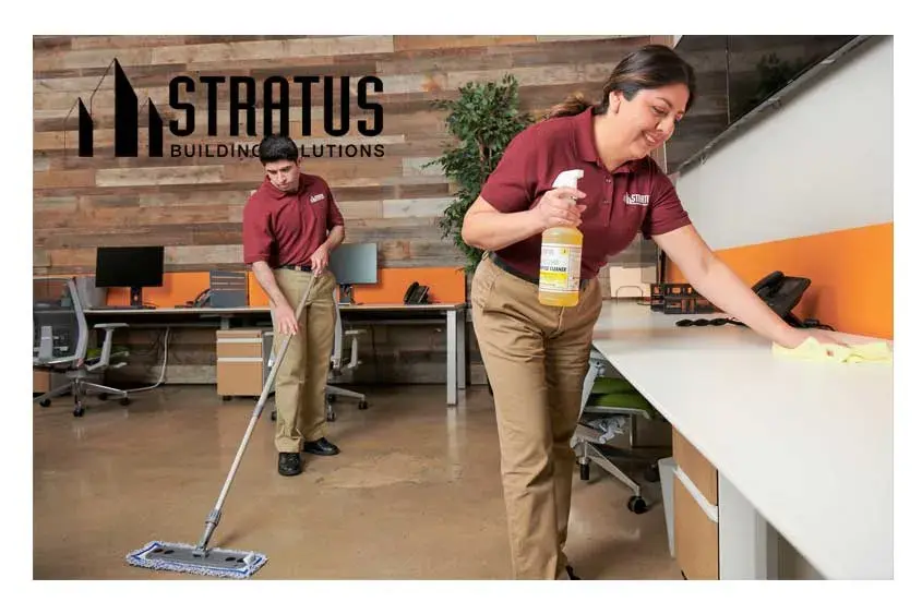 Two Stratus Employees Wearing Branded Polos Smile and Hold Various Cleaning Tools and Products