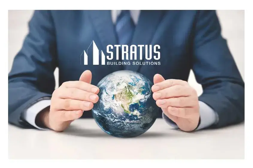 The Torso of a Man in a Blue Business Suit Sitting at a Table with a Hand-Sized Earth Between His Hands With the Stratus Logo